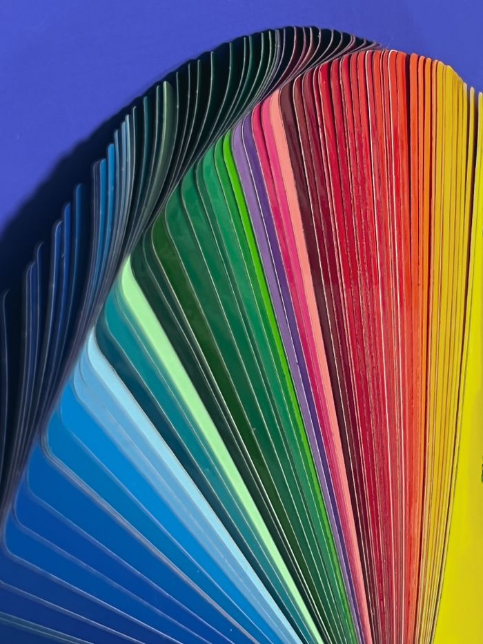services-01 A colorful fan of vibrant color samples in a rainbow spectrum on a blue background.
