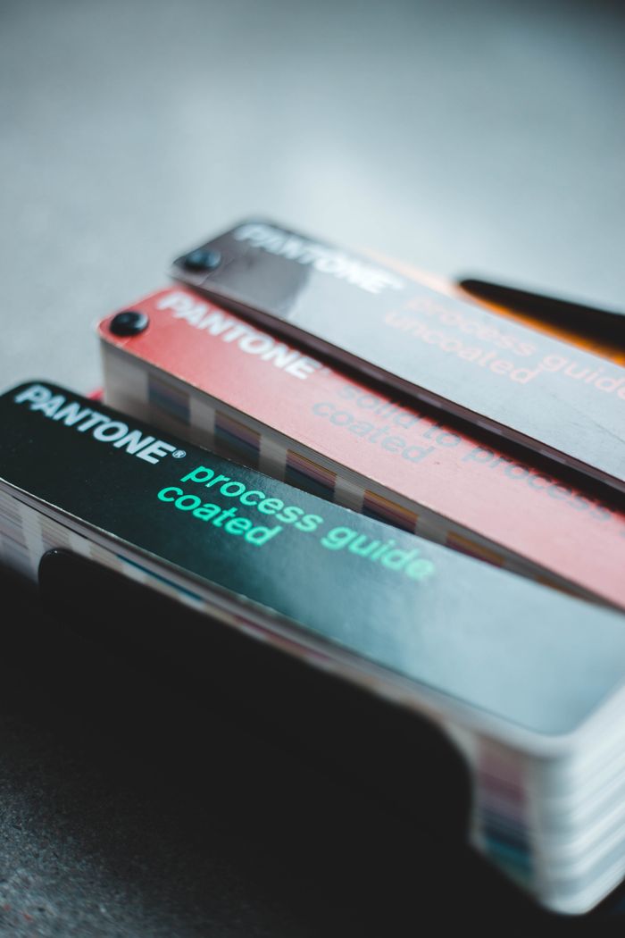 services-img Close-up of Pantone color swatches with focus on design and color selection.