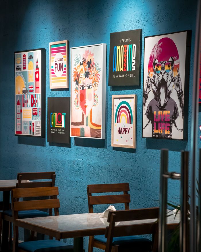 Vibrant wall art display enhances a cozy cafe interior, perfect for design inspiration.