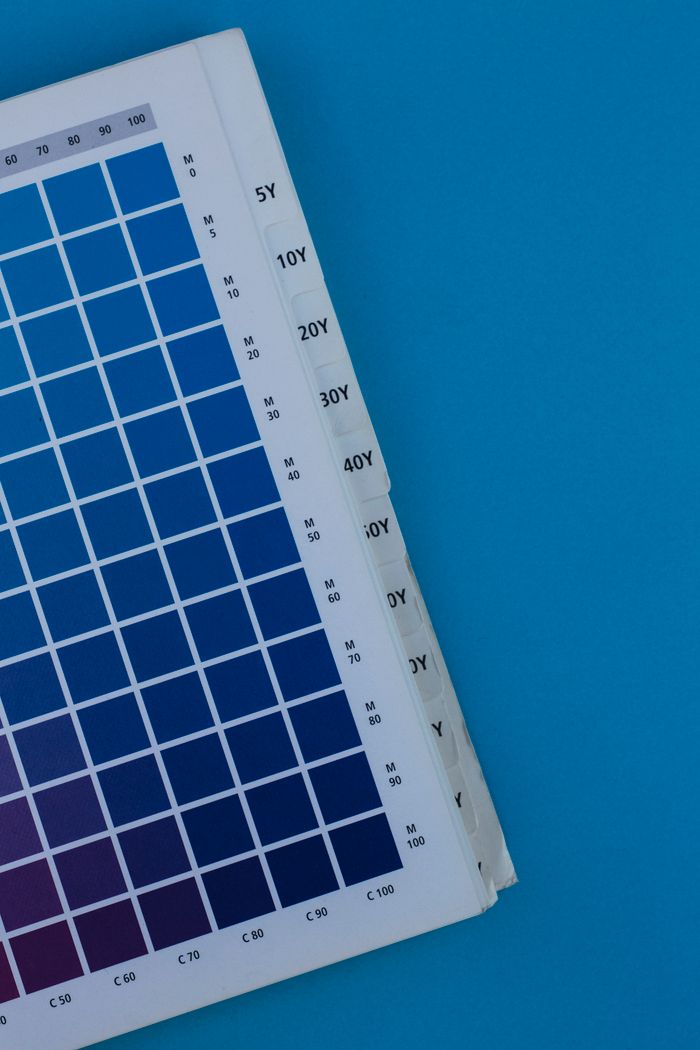 Close-up of a blue gradient color palette on paper against a blue background.